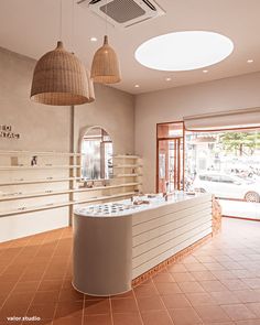 the interior of a store with two lamps hanging from the ceiling and an empty counter