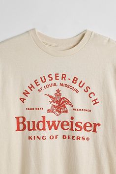 Tee with Budweiser graphics printed at the front. Cotton jersey t-shirt in a standard fit with short sleeves & a ribbed knit crew neck. Features Budweiser graphic tee Regular fit Short sleeves Crew neckline Content + Care 100% Cotton Machine wash Imported Size + Fit Model in Grey is 6'1.5" and wearing size Medium Measurements taken from size Medium Chest: 42" Length: 28" | Budweiser King Of Beers Tee in Ivory at Urban Outfitters College Shirt Design, College Shirts, Graphic Tees Vintage, Trendy Graphic Tees, Graphic Tee Design, Beer Shirts, Tee Shirt Designs, Trendy Shirts, Retro Shirts