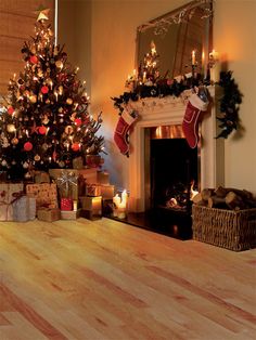 a decorated christmas tree sitting next to a fireplace