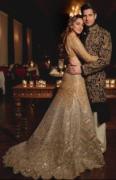 a man and woman dressed in gold posing for a photo