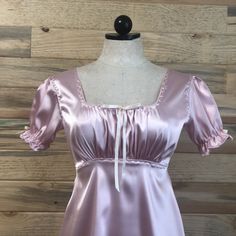 Soft satin babydoll style dress with ribbon detailing. Feminine Satin Dress With Satin Bow, Fitted Satin Finish Dress For Daywear, Pink Satin Coquette Dress, Feminine Dresses With Satin Trim, Coquette Satin Wedding Dress, Satin Babydoll, Babydoll Style Dress, Marilyn Dress, Dress With Ribbon