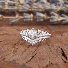 a close up of a wedding ring on a piece of wood with flowers in the background