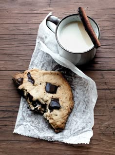 a chocolate chip cookie next to a cup of milk