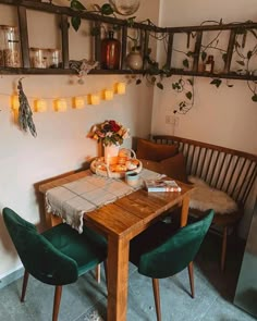 a wooden table topped with plates of food next to a green chair and wall mounted planter