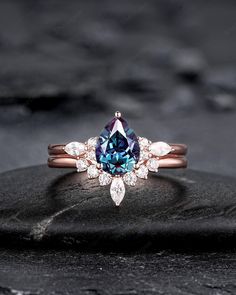 an engagement ring with a blue and white diamond in the center on top of a rock