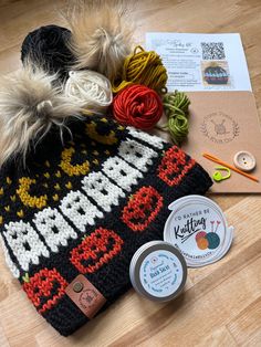 a knitted hat sitting on top of a wooden floor next to yarn and scissors