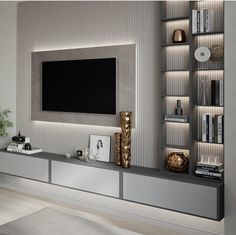 a living room with a large tv mounted on the wall and bookshelves in front of it