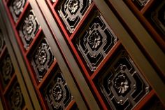 an ornate wooden door with intricate carvings on it's sides and red trim around the edges