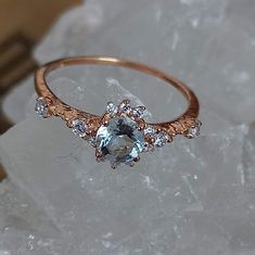 an engagement ring with a blue topazte surrounded by white and brown diamonds on a rock