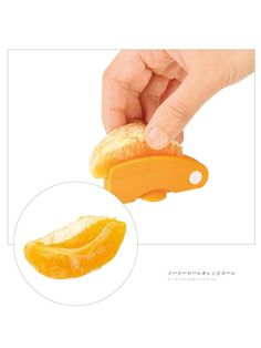 an orange peeler being used to slice an orange in half with the help of a person's hand