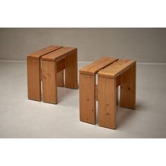 two small wooden stools sitting on top of a white floor next to each other