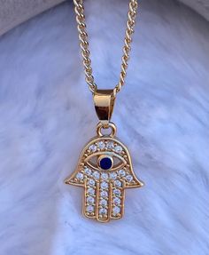 Hamsa Evil Eye Charm pendant  Necklace,  CZ stones on Hamsa Hand   Brazilian Gold Layered, Great Quality  Measures 20 inches in length Gold Crystal Charm Necklaces, Jeweled Cubic Zirconia Necklaces For Gifts, Cubic Zirconia Jeweled Necklace Gift, Jeweled Cubic Zirconia Necklace Gift, Gold Jeweled Necklace For Gift, Gold Plated Jeweled Necklaces As Gifts, Gold Jeweled Crystal Necklace As A Gift, Gold Jeweled Crystal Necklace For Gift, Gold Pendant Necklace With Rhinestones