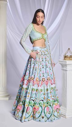 Like a breath of fresh air, our ice blue sequin-printed lehenga comes with pockets! Adorned with opulent gold embellishments, pearls, crystals and 3d flowers. Paired with a full-sleeve embroidered blouse with pearls, crystals, pink enamelled drops and glass stones along with a matching tulle dupatta filled with acrylics, crystals and a pearl border. Blue Hand Embellished Anarkali Set For Festive Occasions, Bollywood Style Hand Embellished Blue Sets, Festive Blue Hand Embellished Anarkali Set, Blue Anarkali Set Hand Embellished, Blue Anarkali Sets With Hand Embellished Details, Blue Hand Embellished Anarkali Set, Hand Embellished Blue Anarkali Set, Light Blue Bollywood Dress With Intricate Embroidery, Designer Anarkali Lehenga In Light Blue