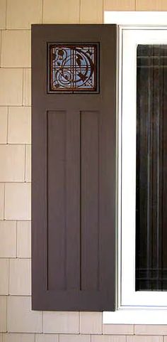 an open window on the side of a brick building with a decorative glass paneled door