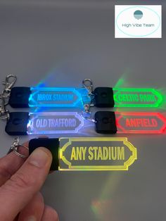 a hand is holding an led keychain that says,'any stadium '