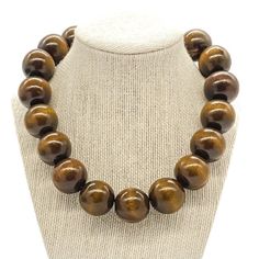 "Beautiful chunky brown wood bead necklace. This statement necklace is made with natural dyed and waxed large brown wooden beads. The necklace hangs 18\" long with a 2\" extender chain.     Details: *25 mm dyed & waxed wooden beads *Silver plated lobster clasp with 2\" extender chain Note:  **Please refer to size ranges and notes. Macro photography is used to show details but can make look larger than its actual size. If you have any questions regarding this item, please hit the \"Ask a Question Brown Bead Necklace, Wooden Bead Necklace, Wood Bead Necklace, Necklace Chunky, Wood Necklace, African Jewelry, Chunky Necklace, Naturally Dyed, Brown Wood