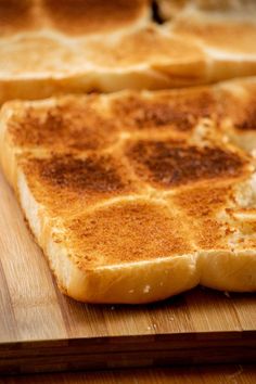 two pieces of bread sitting on top of a wooden cutting board