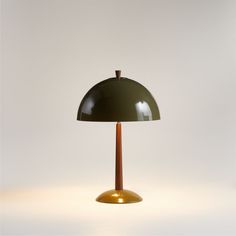 a green table lamp sitting on top of a white floor