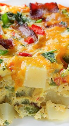 a casserole with cheese, broccoli and peppers on it is sitting on a white plate