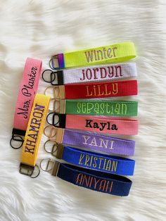 six lanyards with name tags on them sitting on a white furnishing