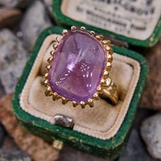 This stunning handmade vintage ring features a rectangular sugarloaf style amethyst cabochon in a twenty-six prong setting. The ring is crafted in a soft 14k yellow gold and is currently a size 7. Formal Cabochon Amethyst Ring Fine Jewelry, Rectangular Amethyst Ring For Formal Events, Rectangular Amethyst Ring For Formal Occasions, Elegant Amethyst Cabochon Ring, Elegant Rectangular Amethyst Ring In Yellow Gold, Luxury Purple Amethyst Ring, Rectangular Shape, Luxury Purple Amethyst Rectangular Ring, Luxury Purple Rectangular Amethyst Ring, Formal Purple Amethyst Ring With Rectangular Shape