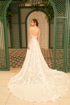 a woman in a wedding dress is standing on the floor with her back to the camera