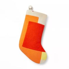 an orange and white christmas stocking hanging on a wall