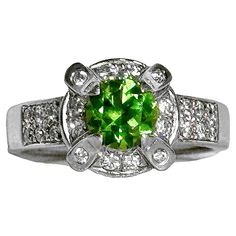 This captivating ring fashioned in platinum features one center brilliant cut demantoid garnet surrounded by diamonds. The origin of the word demantoid derives from the Flemish word 'demant' meaning diamond, due to its diamond like luster and dispersion. Hence, the term demantoid garnet refers to this very rare and unusual stone. Possessing a vibrant yellowish green color, this beautiful gem is ideal for the discerning collector. Underneath the 1.05ct demantoid are pave' set diamonds, as well as Vintage Platinum Rings, Rhodolite Garnet Ring, Demantoid Garnet, Yellowish Green, Diamond Free, Diamond Settings, Platinum Ring, Diamond Solitaire Rings, Diamond Solitaire Engagement Ring