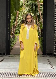 Illuminate your style with our Crepe Oversized Kaftan in the radiant Yellow color. This kaftan beautifully combines tradition and modernity, showcasing the artistry of Moroccan craftsmanship.   Product Details:      V-Neck Kaftan with Handmade "Sfeefa" Finish : The Crepe Oversized Kaftan features an elegant V-neck design adorned with our signature handmade "sfeefa" for a touch of Moroccan opulence.     Handmade Embroideries : Delicate handmade embroideries grace the neckline and front of this ka Bohemian Abaya With Traditional Drape, Festive Floor-length Yellow Kaftan, Traditional Yellow Kaftan For Eid, Yellow Bohemian Kaftan For Festive Season, Yellow Bohemian Kaftan For Festive Occasions, Elegant Traditional Drape Kaftan For Spring, Elegant Summer Tunic Thobe, Festive Yellow Bohemian Kaftan, Festive Bohemian Yellow Kaftan