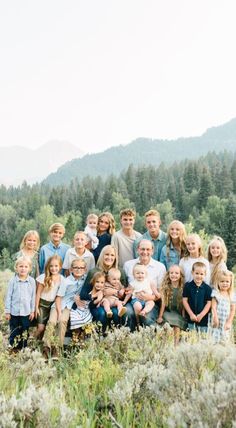 a large group of children and adults posing for a photo in front of some mountains