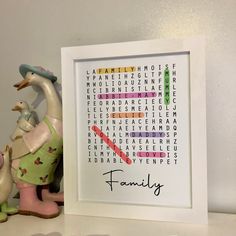 a crossword puzzle in a white frame next to a figurine on a shelf