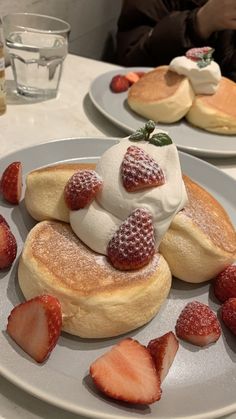 pancakes with whipped cream and strawberries on a plate