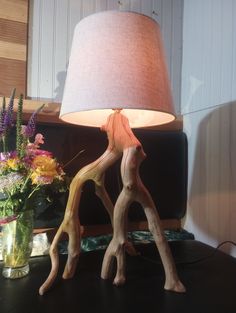 a lamp that is on top of a table next to some flowers and vases