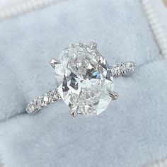 an oval cut diamond ring with pave set shoulders