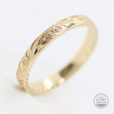 a yellow gold wedding ring with an intricate design