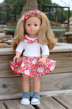 a doll with blonde hair wearing a red and white dress, blue shoes and headband