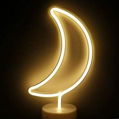 a white candle with a light up crescent on it's side in the dark