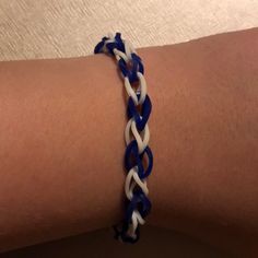 a close up of a person wearing a blue and white bracelet