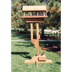 a wooden bird feeder in the grass