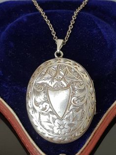 "Gorgeous sterling silver Antique Victorian Aesthetic (circa 1880's, no hallmarks, common in this era, however tested as silver)  ornately engraved double sided locket finely detailed with vacant cartouche in the shape of a shield surrounded by flowers and ivy leaves with decorative border.  To the other side, is a \"greek key meander\" design signifying \"eternity\" again surrounded by decorative ivy leaves and scrolls.  A beautiful piece that looks like it was originally gilded (gold on silver) as it has very slight traces of this which is seen in the photos and can also be worn either way be worn either way around as a new (more modern sterling silver clip loop bail)  allows the owner to choose to change it around to which is side preferred. Opens at the side and closes well to reveal t Victorian White Gold Medallion Necklace, Ornate Oval White Gold Necklaces, Antique White Gold Necklace With Intricate Design, Ornate Oval White Gold Necklace, Antique Locket Pendant Necklace With Intricate Design, Antique Pendant Locket Necklace With Intricate Design, Vintage Silver Pendant Jewelry, Silver Vintage Charm Classic Jewelry, Victorian Silver Oval Jewelry