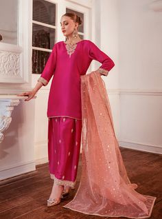 Elevate your style with this intriguing and elegant hot pink silhouette. The ensemble features exquisite embroidered details on the neckline, sleeves and bottom with shade of pink, adding a touch of sophistication and charm. Paired with a contrast organza dupatta, this outfit effortlessly enhances your look, making it perfect for any occasion where you want to make a stylish and memorable impression. Shirt: Raw SilkPants: Raw SilkDupatta: Organza Pink Sets With Dabka Work For Eid, Pink Unstitched Suit With Intricate Embroidery For Party, Elegant Pink Unstitched Suit For Eid, Formal Pink Lehenga With Resham Embroidery, Pink Dabka Work Kurta For Party Wear, Elegant Pink Kurta With Dabka Work, Pink Silk Palazzo Set With Intricate Embroidery, Elegant Pink Unstitched Suit With Dupatta, Elegant Pink Unstitched Suit