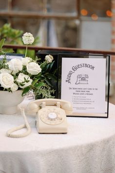 an old fashioned phone sitting on top of a table next to a bouquet of flowers