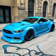 a blue mustang parked in front of a building