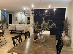 a dining room table with chairs and a chandelier hanging from it's ceiling