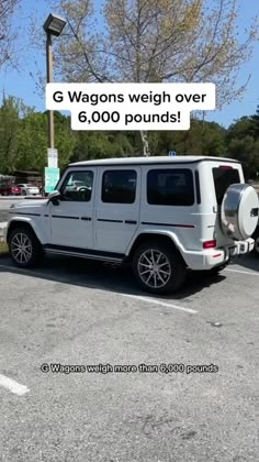 a white jeep parked in a parking lot next to a light pole with the words g wagons weight over 6, 000 pounds