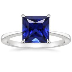 a blue sapphire and diamond ring with two diamonds on the shoulders, set in white gold