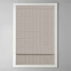 a beige roman blind in front of a white wall