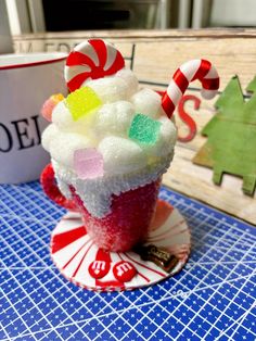 a cupcake with candy canes and candies in it sitting on a plate