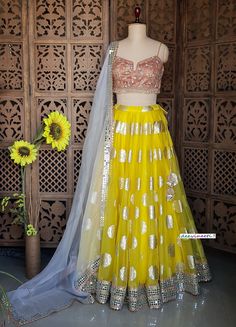 Made to Order/Measurement/Custom Order Lehenga - Color : Yellow - Fabric : Organza with Gold Foil Print and Mirror Border - Fully flared Paneled (kalidaar) lehenga  - Peach Embroidered Spaghetti Blouse - Pure Organza Grey Dupatta with Mirror Border - Drawstring closure with Tassel - Can can attached PLEASE NOTE: BUYERS ARE RESPONSIBLE FOR ANY CUSTOMS AND IMPORT TAXES THAT MAY APPLY. Fabric Care : Dry Clean Only Disclaimer: Please note the photographs are taken by mobile camera in sunlight The ac Lemon Yellow Lehenga Color Combos, Fitted Yellow Organza Sharara, Yellow Fitted Organza Sharara, Fitted Sharara With Gota Work For Reception, Fitted Organza Sharara For Navratri, Fitted Sets With Dori Work In Organza, Fitted Organza Choli With Dori Work, Fitted Organza Sharara For Diwali, Fitted Yellow Sharara With Sheer Dupatta