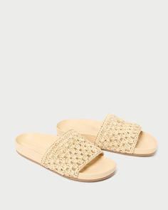 Flat slide sandal in natural crocheted leather. Features a padded leather footbed, a tonal leather sole, and an open toe. Slips on.